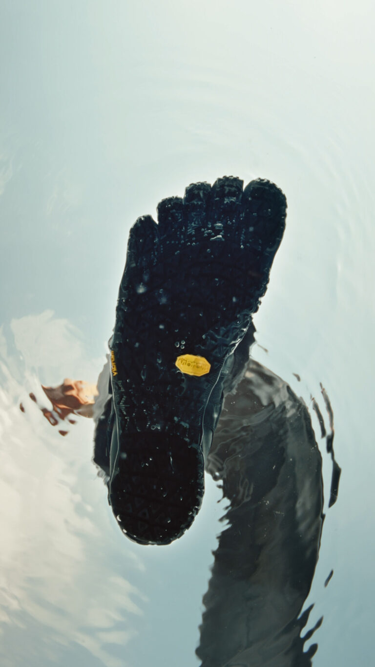 A bottom view of the Vibram FiveFingers sole submerged in water, showcasing the textured sole designed for superior grip and flexibility.